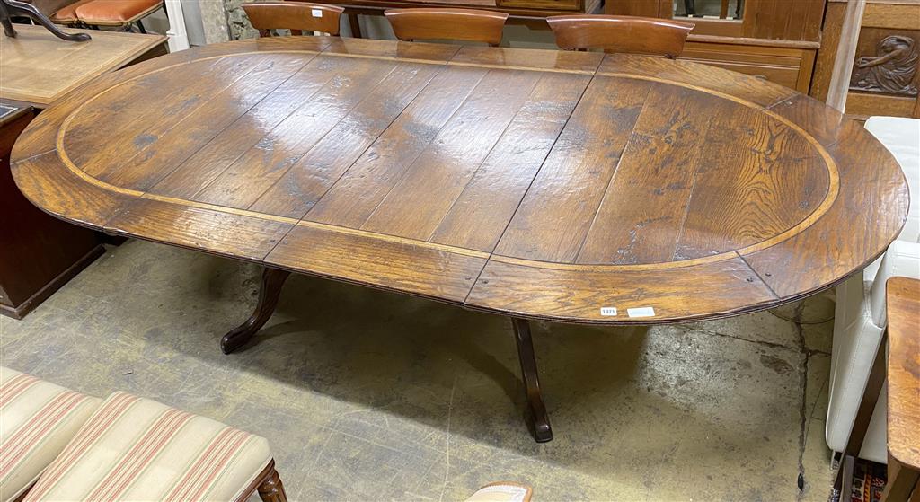 An 18th century style cross banded oak D end twin pillar extending dining table, 284cm extended, two spare leaves, width 130cm, height